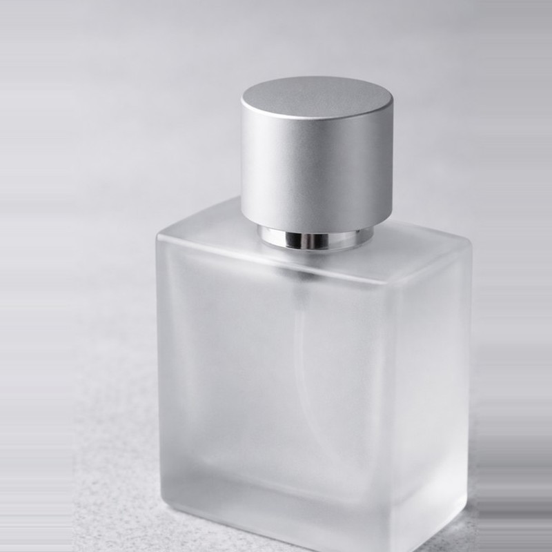 frosted glass perfume bottle with matte cap close-up minimalist luxury packaging